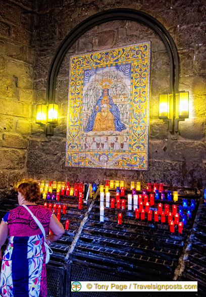 Pilgrims leave candles as offerings to Our Lady on exiting the Niche