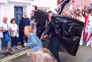 The red 'obby 'oss capturing a passing maiden during the Padstow Mayday festival