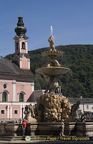 Baroque Residenz fountain with St. Michael's Church in the background