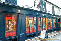 Exterior of Cafe Procope with images of its famous clientele