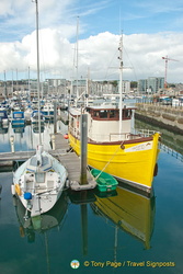 An attractive yellow wooden boat in Sutton Harbour Marina