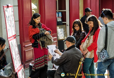 A group of Indian visitors having their caricature sketched