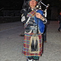 A lone piper plays as guests arrive