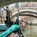 The skillful gondolier navigates under the many bridges