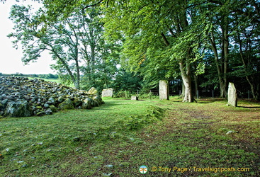 The standing stones are part of the stone circle surrounding the cairn